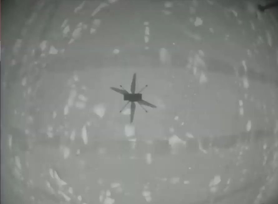 La sombra de Ingenuity mirando hacia la superficie de Marte.