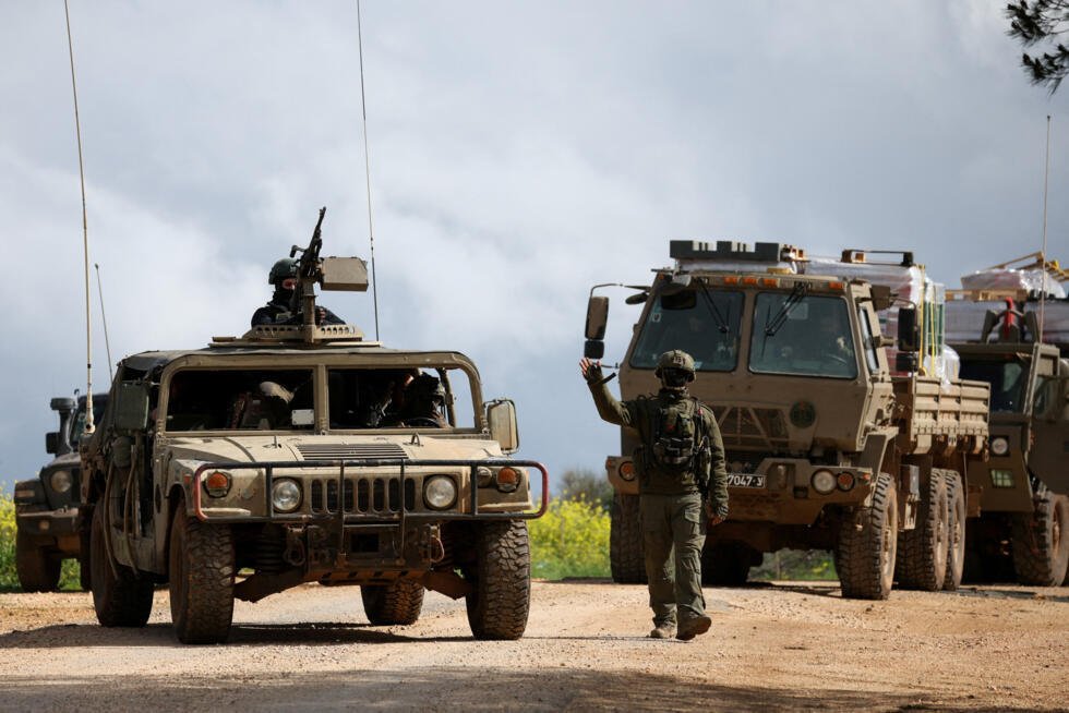 Un soldado israelí hace un gesto mientras camina junto a vehículos militares, después de que las fuerzas israelíes lanzaran una nueva campaña contra Hezbolá, respaldado por Irán, en el sur del Líbano, el 30 de marzo de 2026.