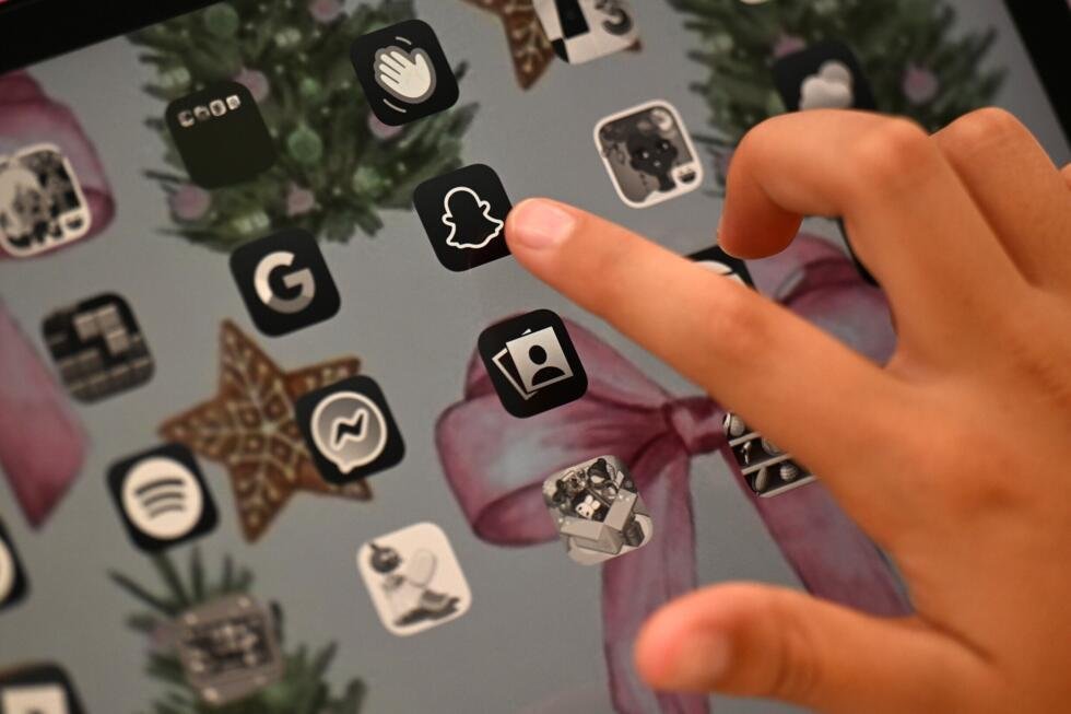 Archivo. Unos adolescentes utilizan sus teléfonos inteligentes a la entrada de su instituto en Tomares, Sevilla, el 6 de febrero de 2026.