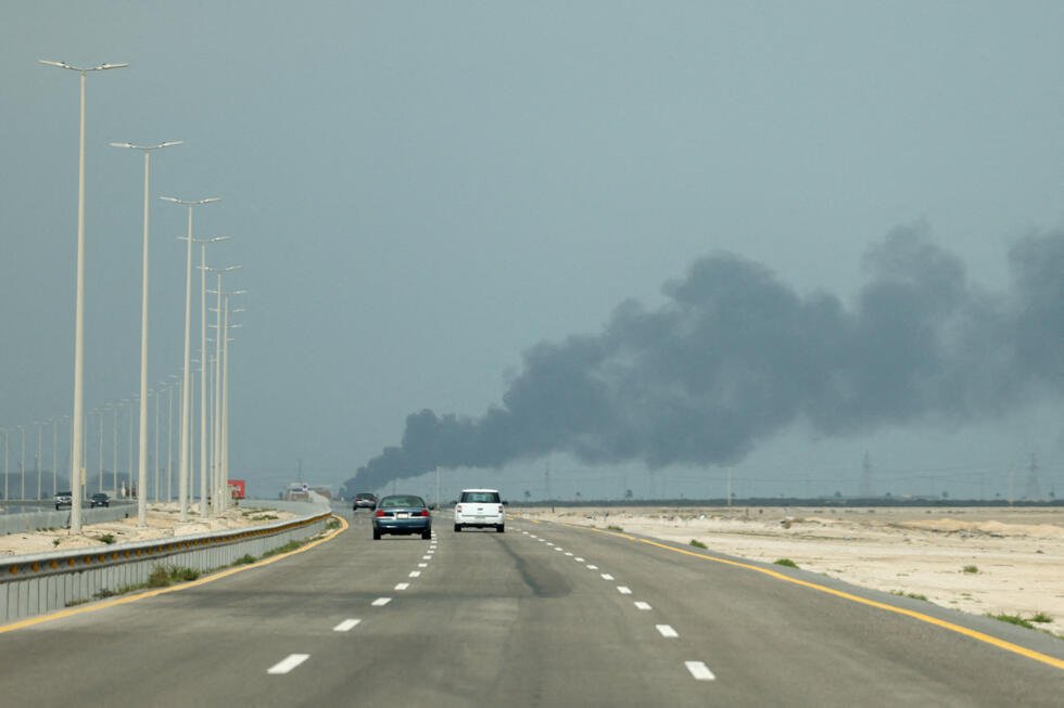 Vehicles move along a road as smoke billows from Saudi Aramco's Ras Tanura oil refinery after a reported Iranian drone strike on March 2, 2026
