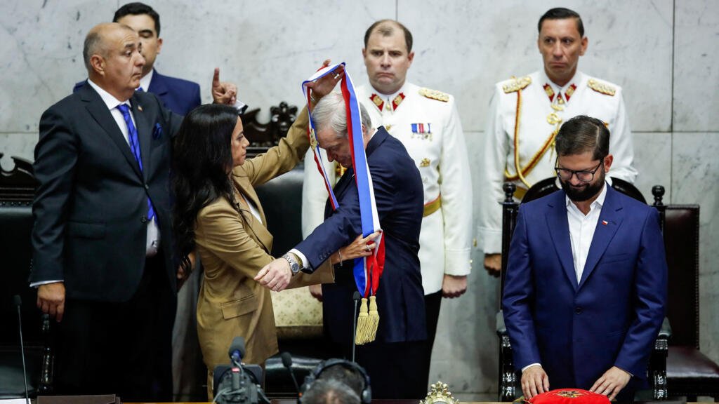 El presidente electo de Chile, José Antonio Kast, recibe la banda presidencial de manos de la senadora Paulina Núñez, mientras el presidente saliente de Chile, Gabriel Boric, observa en el Congreso, en Valparaíso, Chile, el 11 de marzo de 2026.