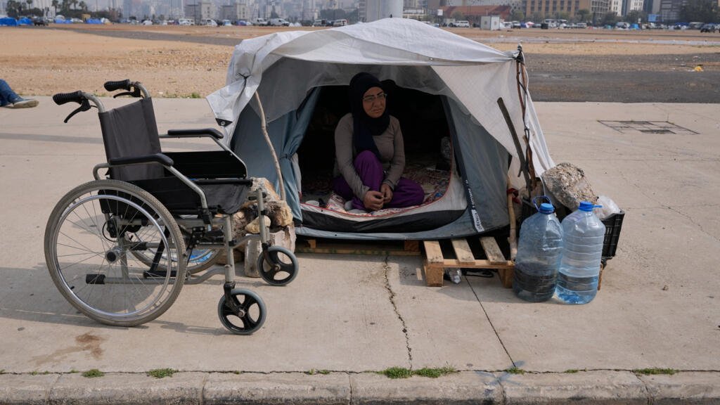 Una mujer discapacitada desplazada que huyó de los ataques israelíes en el sur del Líbano se sienta dentro de su pequeña tienda de campaña, en Beirut (Líbano), el jueves 19 de marzo de 2026.