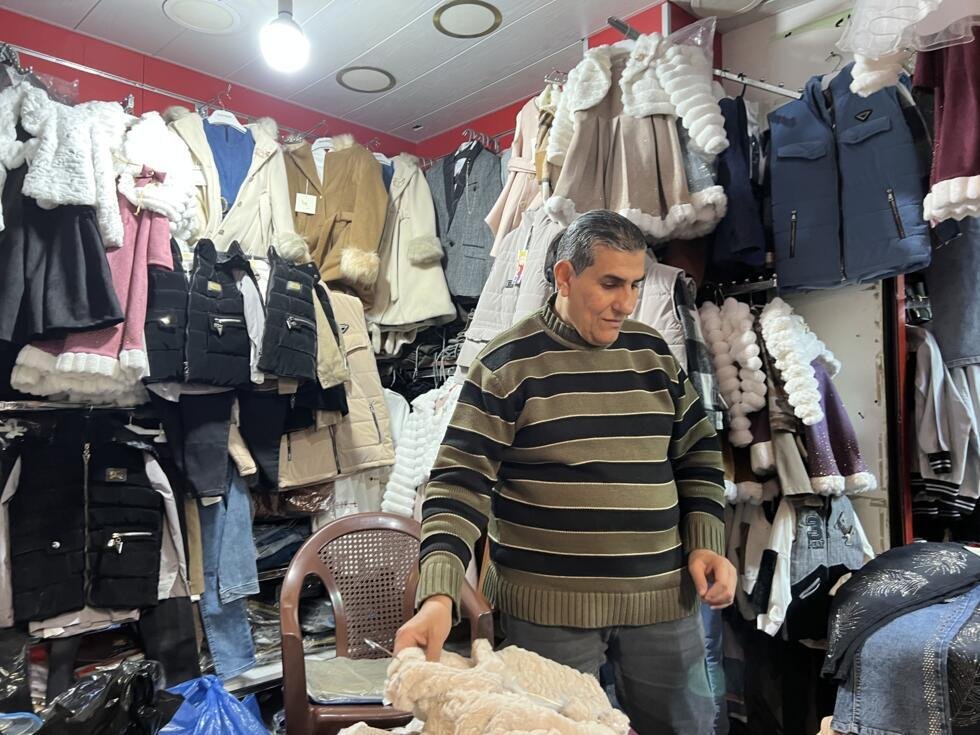 Mahmoud dans sa boutique de vêtements pour enfants.