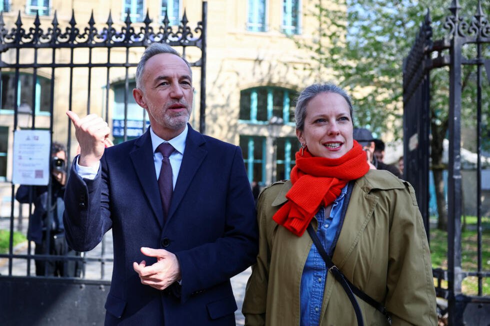 Emmanuel Grégoire, candidato a la alcaldía de París por el Partido Socialista y jefe de la lista de la coalición de izquierdas, y Lucie Castet, candidata a alcalde del distrito 12, se marchan tras votar en la segunda vuelta de las elecciones en París. 22 de marzo de 2026.