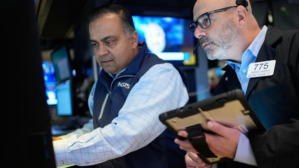 Federico DeMarco, a la derecha, y Dilip Patel trabajan en el suelo de la Bolsa de Nueva York en Nueva York, miércoles 25 de marzo de 2026.