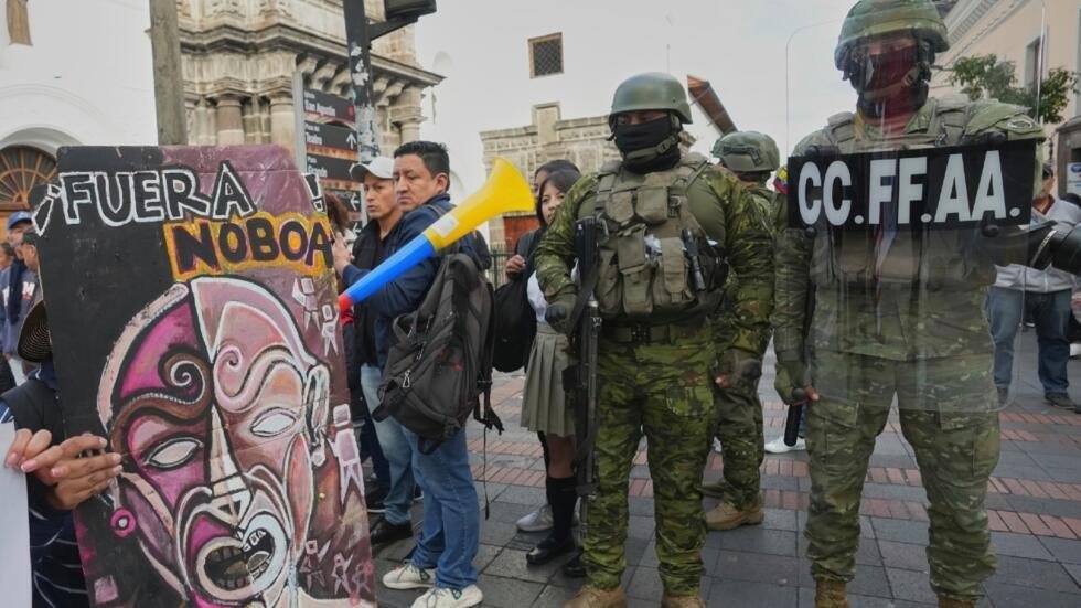 Policías permanecen de pie junto a manifestantes que participan en una protesta antigubernamental en Quito, Ecuador, el 13 de marzo de 2026.