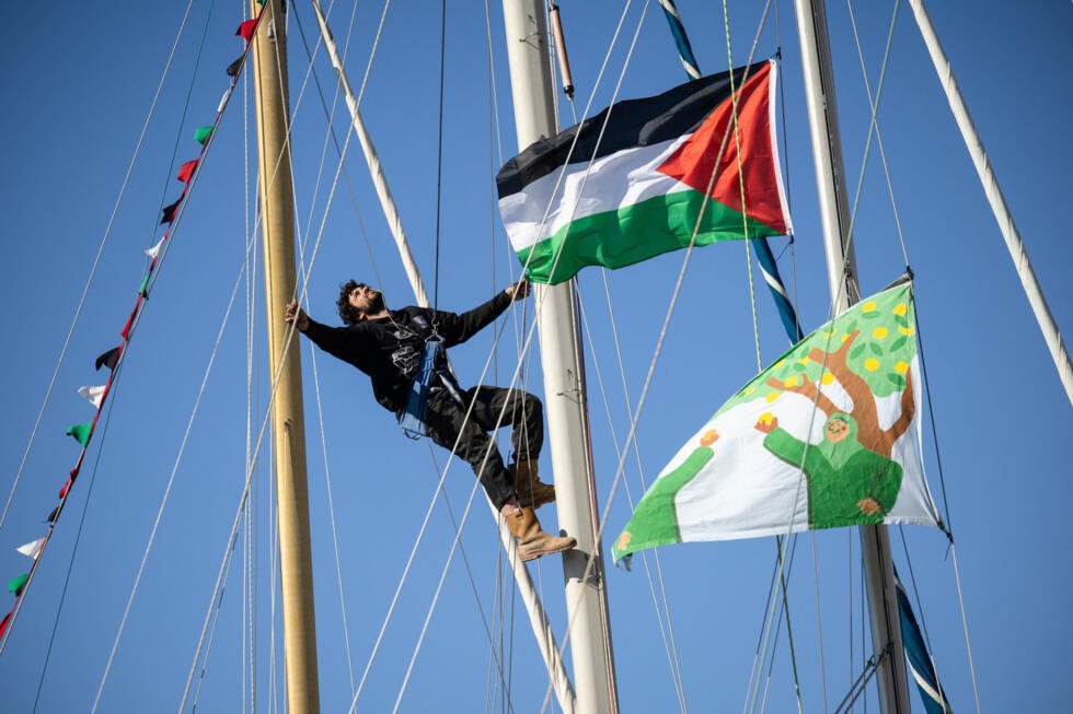 Un militant grimpe au mât d'un bateau arborant un drapeau palestinien, le 4 avril 2026, à l'Estaque, dans le port de Marseille