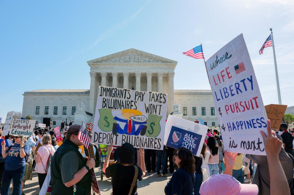 Manifestantes portan pancartas frente al edificio de la Corte Suprema de Estados Unidos mientras el tribunal escucha los argumentos orales sobre la legalidad del intento del gobierno de Trump de limitar la ciudadanía por derecho de nacimiento para los hijos de inmigrantes, en Washington, D.C., EE. UU., 1 de abril de 2026.