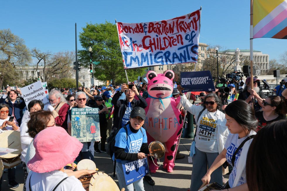 Un manifestante disfrazado sostiene una pancarta que hace referencia al presidente estadounidense Donald Trump y a su hijo Barron Trump cerca del edificio de la Corte Suprema de Estados Unidos, el día en que se espera que la corte escuche los argumentos orales sobre la legalidad del intento de la administración Trump de limitar la ciudadanía por derecho de nacimiento para los hijos de inmigrantes, en Washington, D.C., Estados Unidos, 1 de abril de 2026.
