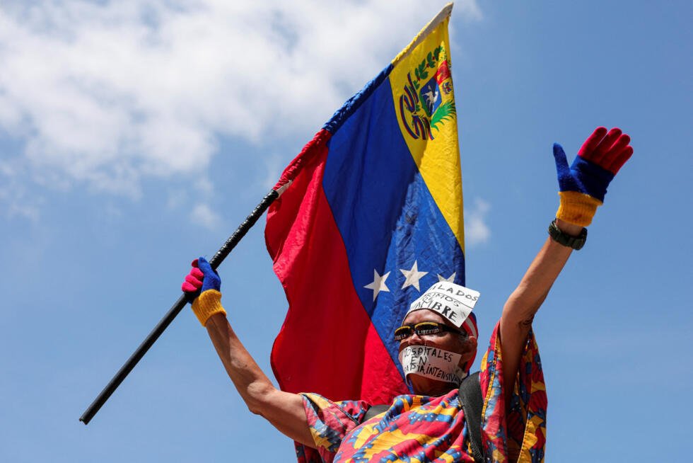 Una mujer ondea una bandera venezolana durante una protesta para exigir mejores salarios y condiciones laborales, en Caracas, Venezuela, el 25 de marzo de 2026.